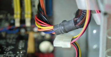 Gros plan sur le câblage interne et les composants électroniques d'un appareil connecté, illustrant les vulnérabilités matérielles exploitées pour le minage de cryptomonnaie.