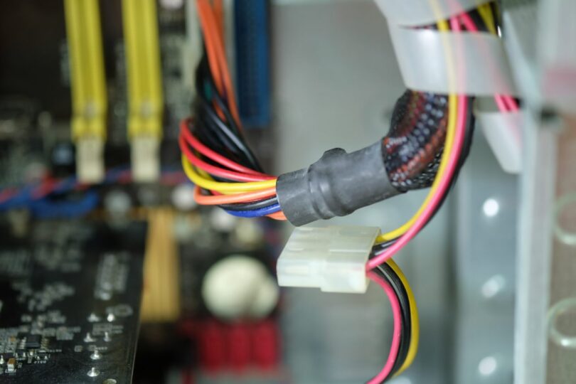 Gros plan sur le câblage interne et les composants électroniques d'un appareil connecté, illustrant les vulnérabilités matérielles exploitées pour le minage de cryptomonnaie.