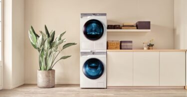 Duo de lave-linge et sèche-linge Samsung blanc au design épuré, installés en colonne dans une buanderie moderne et lumineuse, illustrant la nouvelle gamme équipée d'intelligence artificielle.